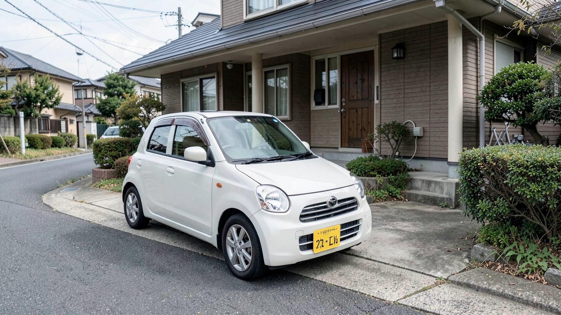 住宅街の駐車スペースに停められた軽自動車
